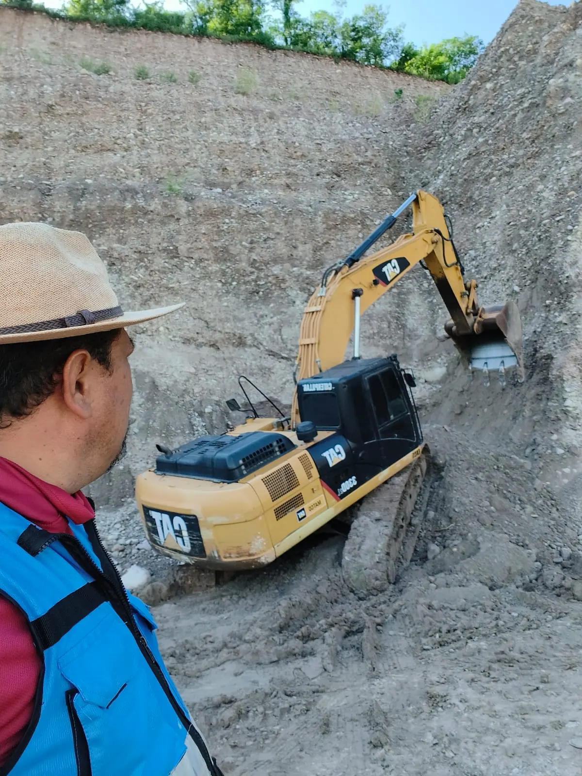 Excavadora CAT cargando material en un banco de grava